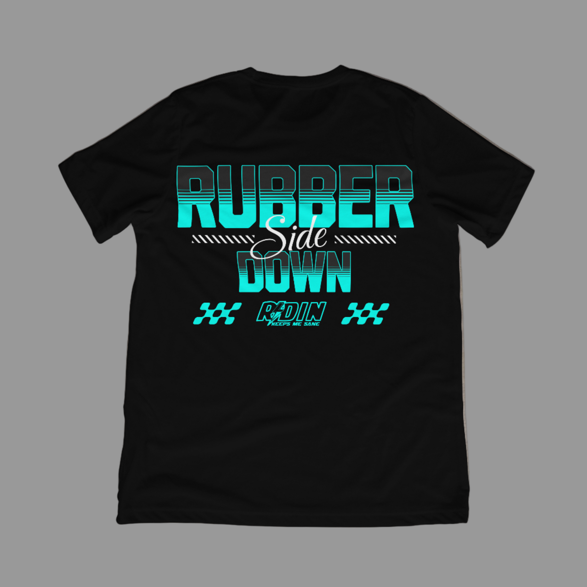 Black t-shirt with teal and white text on a concrete floor